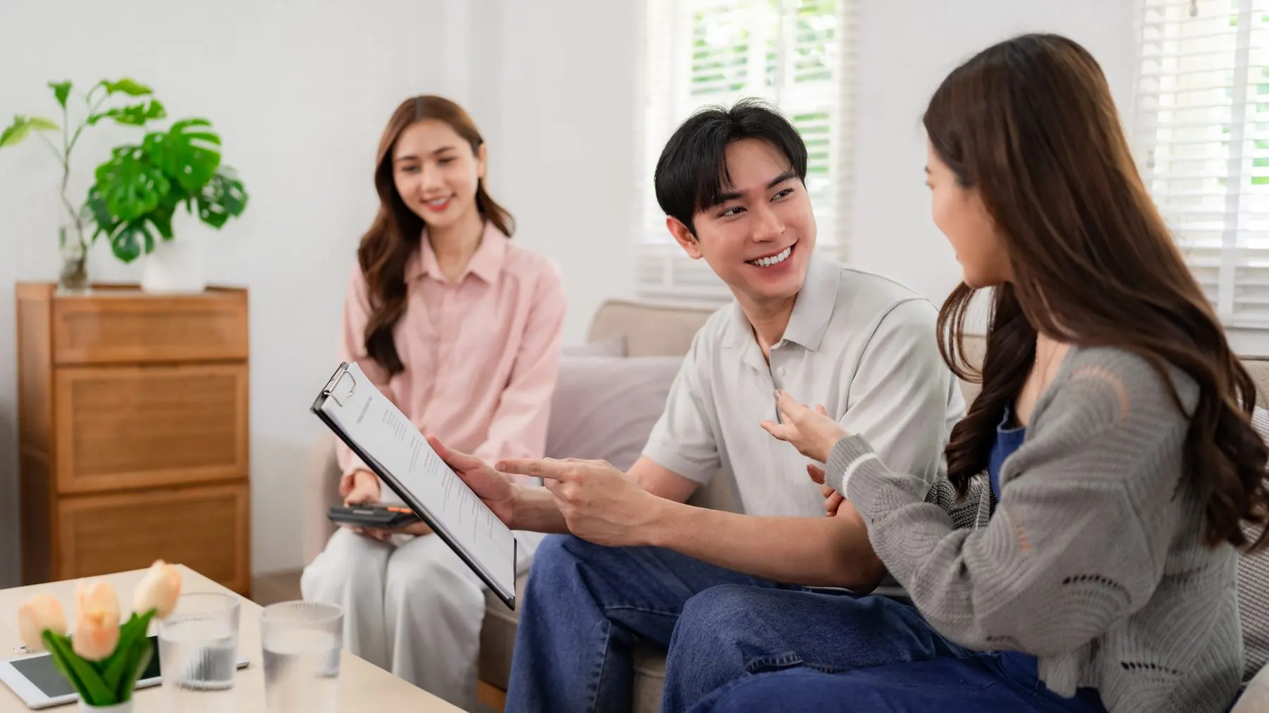 担当者とタブレットの書類を確かめる夫婦