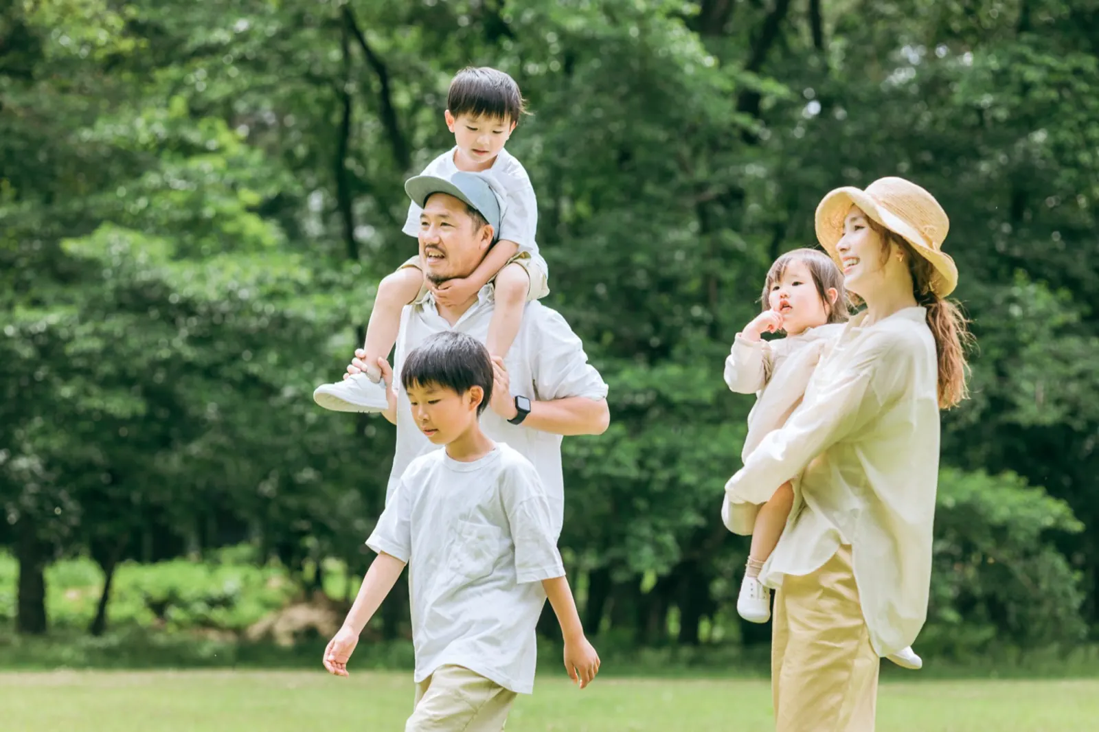 緑の公園を歩く家族