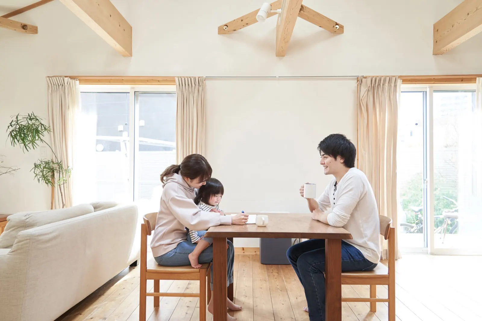 明るいダイニングで話し合う両親と子ども